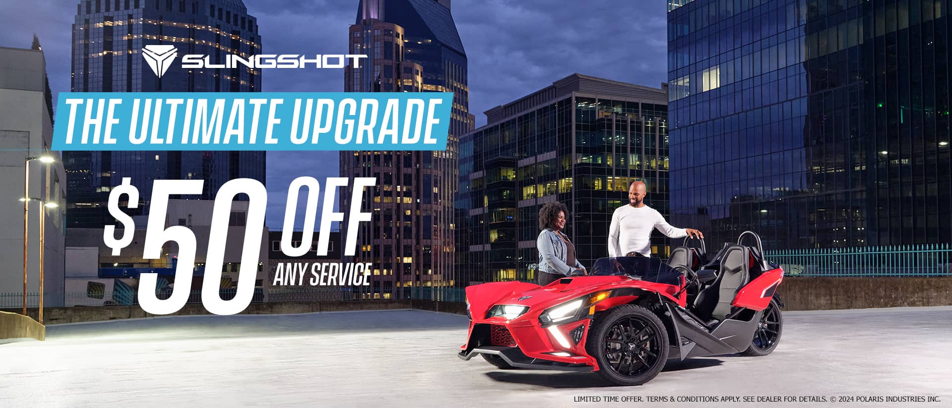 A man and a woman standing next to a red slingshot in an empty lot. Promotional Offer: The ultimate upgrade. $50 off any service.