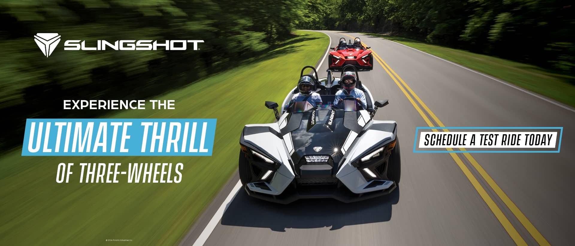 A white and a red Slingshot driving down a highway. Experience the ultimate thrill of three-wheels. Schedule a test ride today.